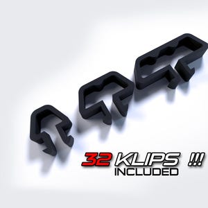 May include: A set of 32 black plastic cable clips, designed to help organize and manage cables. The image shows a close-up of the clips, along with a diagram of how they can be used. The text "32 KLIPS!!! INCLUDED" and "KLIPTECH CABLE MANAGEMENT SYSTEM" is also visible.