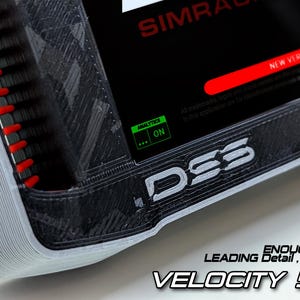 May include: A black and grey Velocity 5in DDU sim racing display unit with a textured 3D printed frame, red side accents, and a screen showing SIMRACING text, a new version notification, and an analytics on indicator. The text D5S is visible.