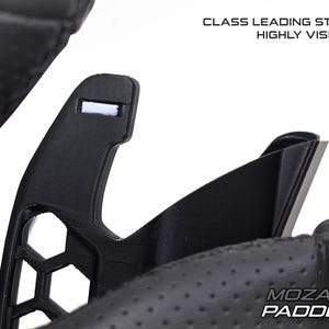 May include: Close-up of a black steering wheel paddle with a honeycomb design and the text "MOZA PADDLE PRO XT". The image also includes the text "CLASS LEADING STYLE HIGHLY VISIBLE".
