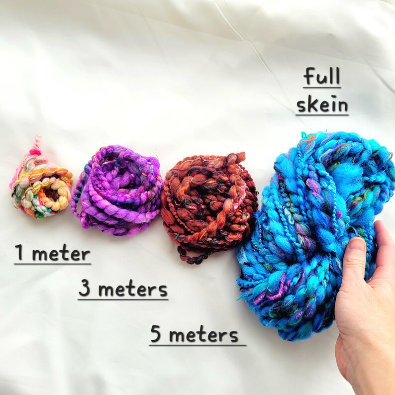Op de afbeelding: Vier bollen kleurrijk garen in verschillende maten. De kleinste bol is 1 meter lang, de volgende is 3 meter lang, de volgende is 5 meter lang en de grootste bol is een volle bol.