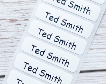 May include: Ten white rectangular labels with black text that reads "Ted Smith" on each label.