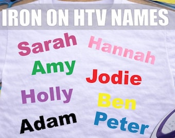 May include: White t-shirt with colourful iron-on names: Sarah, Amy, Holly, Adam, Hannah, Jodie, Ben, and Peter. The text "IRON ON HTV NAMES" is at the top. A purple iron and scissors are in the background.