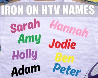 May include: White t-shirt with the words "IRON ON HTV NAMES" in white block letters. The names Sarah, Amy, Holly, Adam, Hannah, Jodie, Ben, and Peter are displayed in various colors. A purple and white iron is visible.