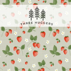 May include: A repeating pattern featuring red strawberries, green leaves, and white flowers on a pale green backdrop. The text "THREE HUGGERS" is displayed in a white banner. Ideal for fabric or wallpaper.