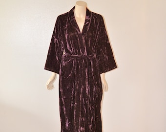 May include: A long, dark purple velvet robe with a shawl collar and a tie belt. The robe is on a white mannequin.