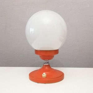 Vintage orange Pop era side table or desk lamp from the 1970&#39;s with white glass globe.