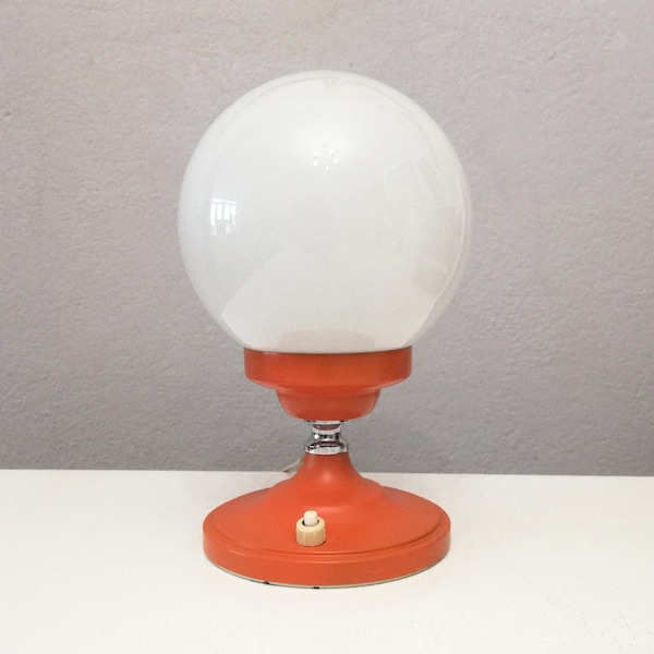 Vintage orange Pop era side table or desk lamp from the 1970's with white glass globe.