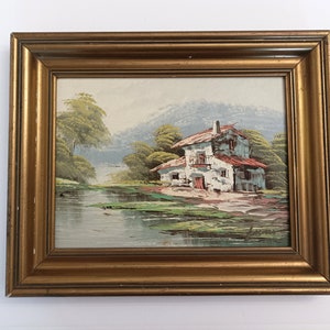 Small original painting on board circa 1960 framed and signed landscape oil painting with gold wooden frame house by the river painting