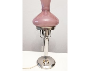May include: A vintage table lamp with a silver base and a pink glass shade.