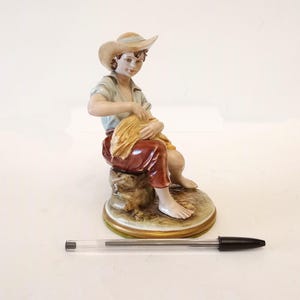 Capodimonte signierte Porzellanfigur eines Jungen mit einem Scheffel Weizen aus Italien um 1970 Vintage Figur eines jungen Mannes sitzend