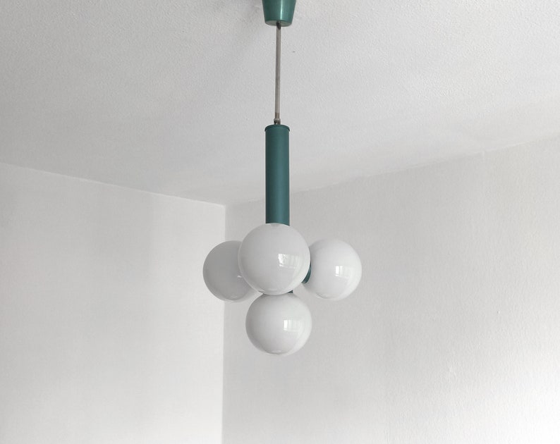 Puede incluir: Una l&aacute;mpara de techo de color turquesa con cinco bombillas blancas en forma de globo.