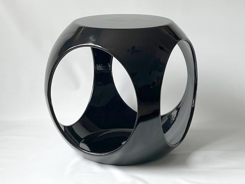 K&ouml;nnte beinhalten: Ein schwarzer, gl&auml;nzender, geometrischer Beistelltisch mit einem einzigartigen, dreidimensionalen Design. Der Tisch hat drei offene Kreise, die einen modernen und stilvollen Look erzeugen.