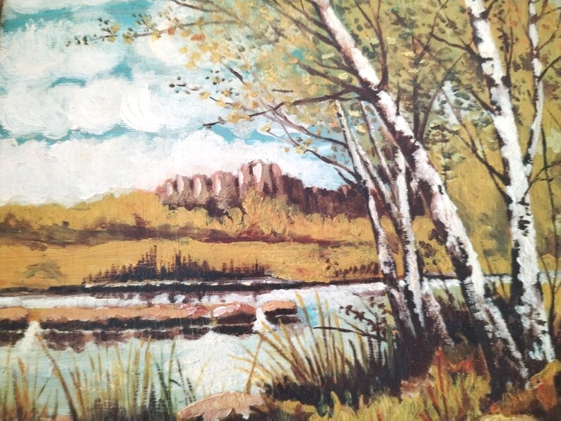 May include: A painting of a landscape with a river, trees, and a distant building. The trees are white birch trees with green leaves. The river is blue and the building is brown. The sky is blue with white clouds.