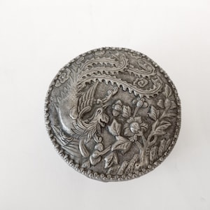 Round metal trinket box with embossed oriental design circa 1960 round silver metal jewellery box with bird and mirror inside