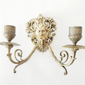 Pair of ornate brass candle wall sconces from France with faces circa 1900 Small French brass candle sconces with satyr