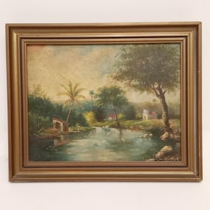 Original French painting on wood circa 1930 framed landscape oil painting with gold wooden frame of houses by the river and treees painting