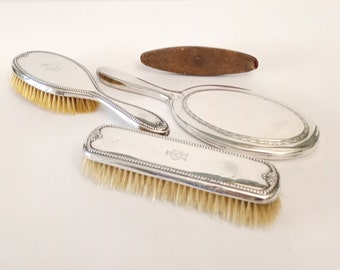 Four piece vanity set with hair brush hand mirror nail buffer coat brush circa 1940 vintage Spanish 916 silver hair and nail care set