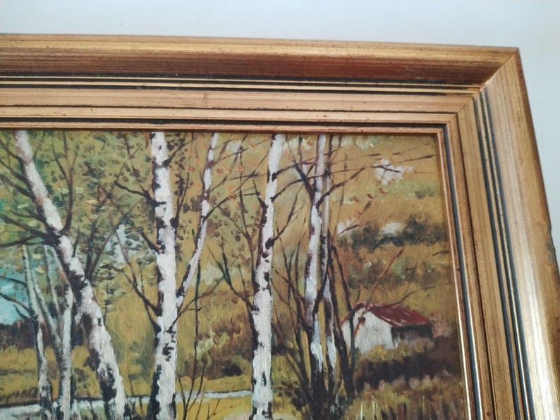 May include: A framed painting depicting a forest scene with birch trees, a small house, and a stream. The painting is done in a realistic style with muted colors.