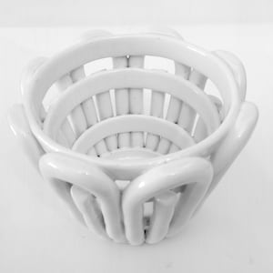 Può includere: Scodella in ceramica bianca con un design intrecciato. La scodella è realizzata con più strati di ceramica, creando un motivo unico e intricato.