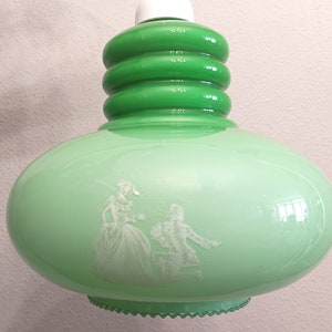 Luminária pendente Mcm em vidro opalino verde, fabricada na década de 1960, com design futurista e cena romântica.