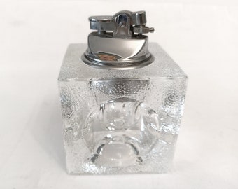 May include: A clear glass lighter with a textured surface and a silver metal top.