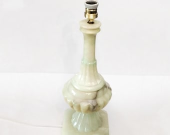Peut inclure: Une lampe de table en albâtre blanc avec une ampoule et une base carrée. La lampe a une teinte verte et un design décoratif.