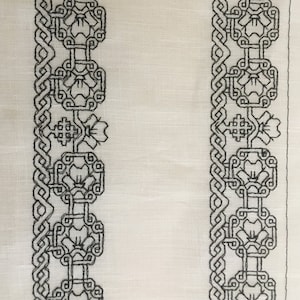 May include: White fabric with black embroidered designs. The design features a repeating pattern of interlocking circles and flowers.