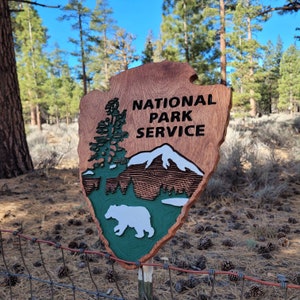 Letrero del Servicio de Parques Nacionales tallado en madera con un oso