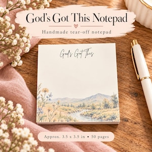 May include: A square tear-off notepad with the text God's Got This printed at the top. The bottom features a landscape illustration of a river, mountains, and wildflowers in muted tones. The notepad measures approximately 3.5 by 3.5 inches.