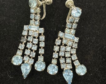 Brincos pendentes vintage em tom prateado com strass azul claro, estilo lustre.