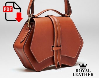 Könnte beinhalten: Eine braune Ledertasche mit geometrischer Form und einem langen Trageriemen. Die Tasche hat einen Klappverschluss und einen dekorativen Riemen mit einer Schnalle. Die Tasche ist von Royal Leather.