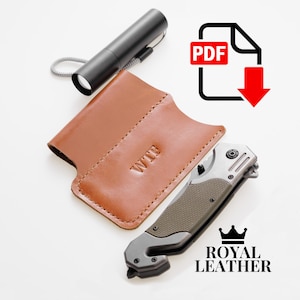 May include: A brown leather wallet with the word "WTF" embossed on it. The wallet is next to a silver pocket knife with a black handle and a black flashlight with a lanyard. The image also includes a PDF download icon and the text "ROYAL LEATHER".