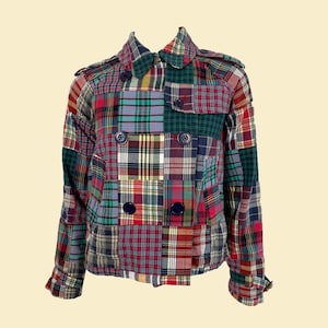 May include: A patchwork jacket with a double breasted closure. The jacket is made of different plaid fabrics in shades of red, blue, green, and white.