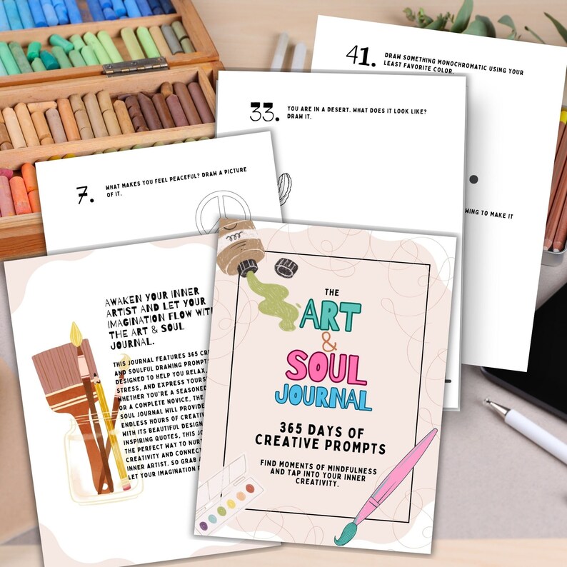 May include: A pink and green journal with the title "The Art & Soul Journal" and the text "365 Days of Creative Prompts". The journal cover features a paintbrush and a palette of paint.
