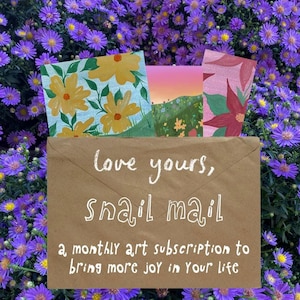 May include: A brown paper envelope with the white text "love yours, snail mail a monthly art subscription to bring more joy in your life" printed on the front. Three colorful illustrated cards with floral and landscape designs peek out.