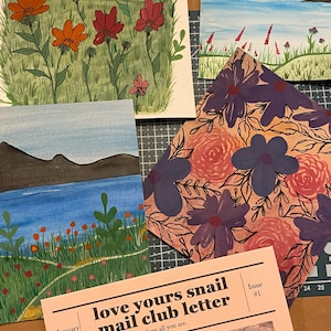May include: A collection of four illustrated cards and a newsletter titled love yours snail mail club letter issue #1 dated January 2026. The artwork features vibrant floral meadows, a blue lake with dark mountains, and a pattern of purple and pink flowers.