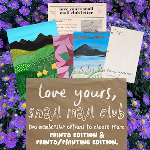 May include: A brown paper envelope with the white text "love yours, snail mail club" and "two membership options to choose from: PRINTS EDITION & PRINTS/PAINTING EDITION." accompanied by a newsletter, two landscape paintings, and a lined note.