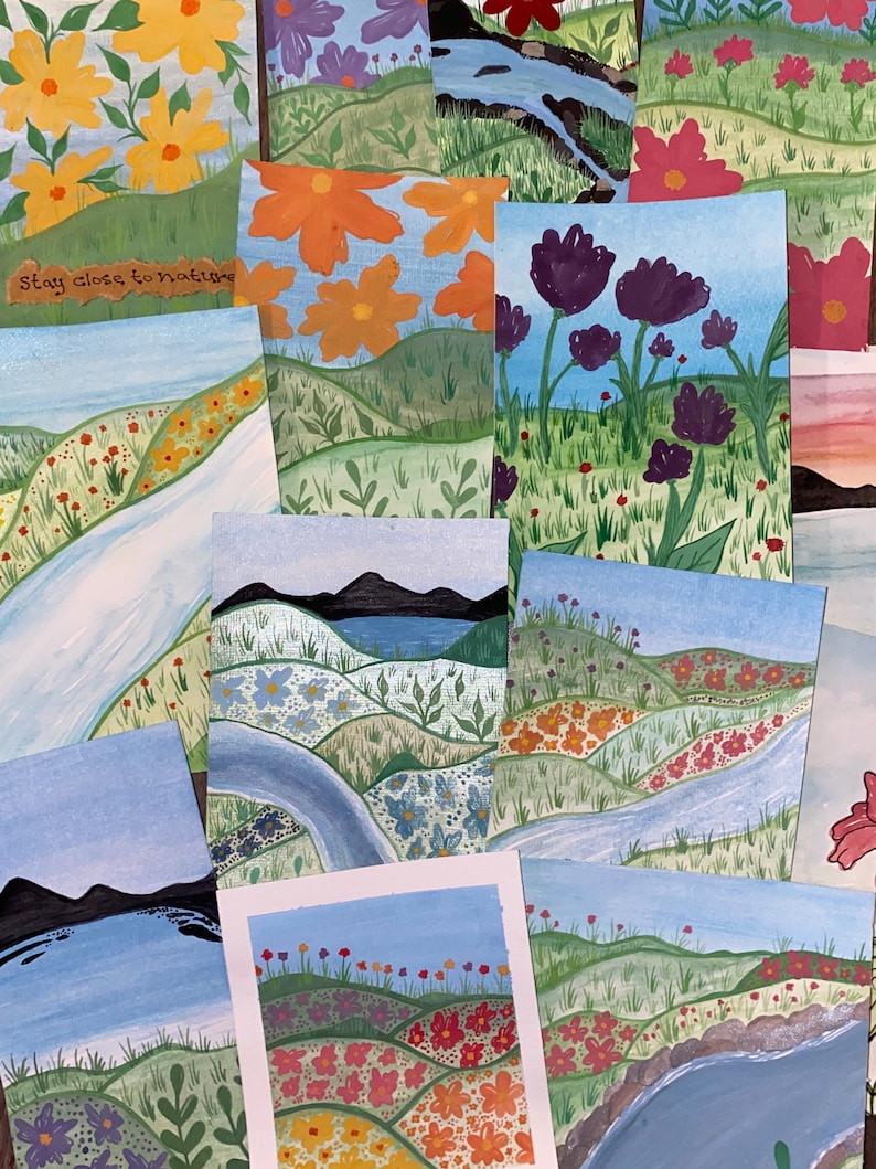 May include: A collection of rectangular art prints featuring hand-painted landscapes with rolling green hills, winding blue rivers, and various colorful flowers. One print includes the text Stay close to nature in brown script lettering.