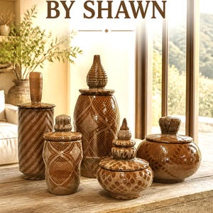May include: Five brown ceramic lidded jars with textured patterns, including diamond and dot motifs. The text HANDMADE BY SHAWN appears at the top, and paintingsandpottery.com | iLoveCeramic.net is printed at the bottom of this display.