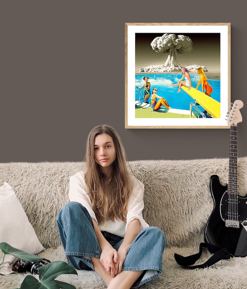 May include: A framed collage of a mushroom cloud explosion over a swimming pool with women in bathing suits. The women are sitting on the edge of the pool and on a diving board.