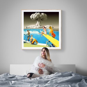 May include: A framed print of a vintage style collage featuring four women in swimsuits at a pool with a mushroom cloud in the background.