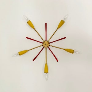May include: A gold and red mid-century modern ceiling light fixture with six yellow glass shades.
