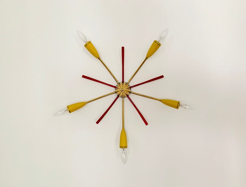 May include: A gold and red mid-century modern ceiling light fixture with six yellow glass shades.