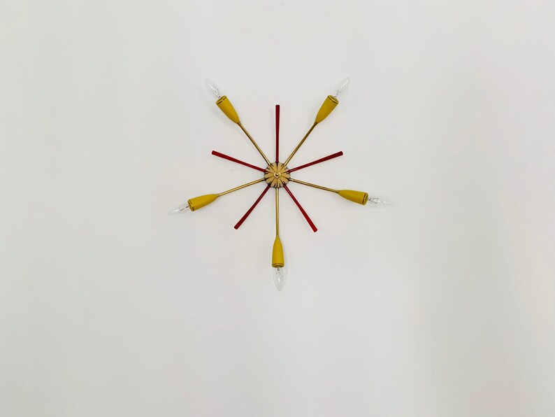 May include: A gold and red starburst ceiling light fixture with six arms and six light bulbs.