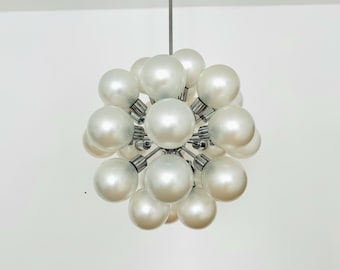 May include: A chrome and white globe-shaped chandelier with multiple round light bulbs.