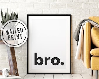 Puede incluir: Impresión enmarcada en blanco y negro con la palabra "bro." impresa en letras negras y negritas sobre un fondo blanco. La impresión está colgada en una pared de ladrillo blanco.