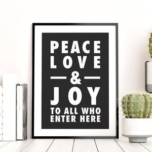 May include: Black and white framed print with the text "Peace Love & Joy to all who enter here".