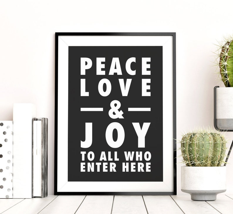 May include: Black and white framed print with the text "Peace Love & Joy to all who enter here".