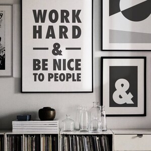 Puede incluir: Impresi&oacute;n enmarcada en blanco y negro con el texto "Work Hard & Be Nice To People". La impresi&oacute;n est&aacute; colgada en una pared con otras impresiones enmarcadas, incluida una que dice "Carpe Diem".