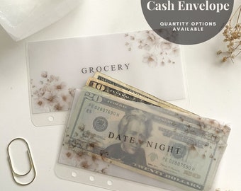 Könnte beinhalten: Transparente Vellum-Bargeldumschläge mit floralen Mustern. Einer ist mit "Grocery" beschriftet, der andere mit "Date Night". Die Umschläge sind transparent und zeigen den Inhalt. Der Text "Minimal Floral" und "Quantity Options Available" ist ebenfalls sichtbar.